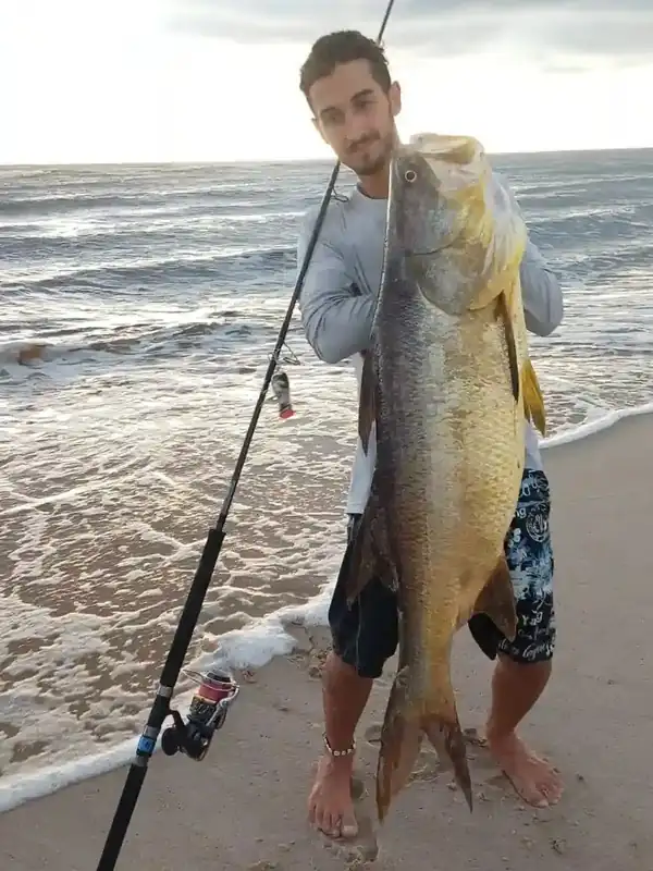 Pêcheur présentant un capiitaine capturé depuis la plage sur la côte gabonaise.