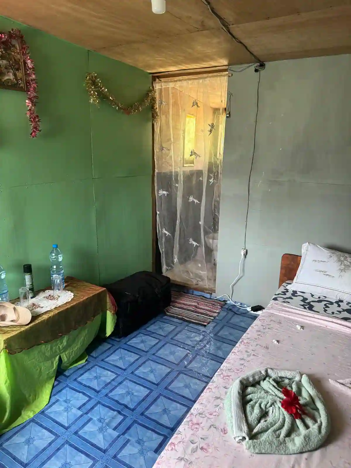 Chambre de Bangué Lodge avec lit double, mobilier simple et ambiance authentique au cœur de la nature gabonaise.