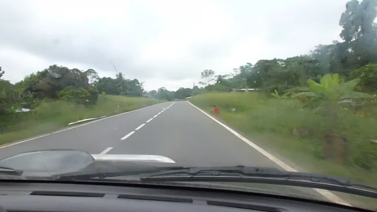 Route reliant Omboué à Iguéla à travers la forêt tropicale gabonaise, dernière étape du trajet terrestre avant l’arrivée à Bangué Lodge.