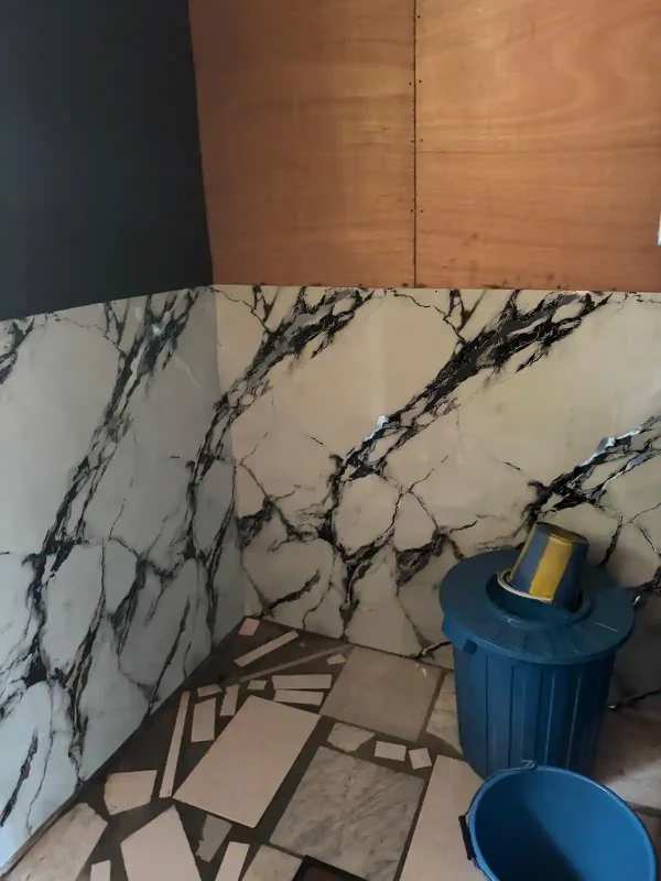Espace sanitaire rénové de Bangué Lodge avec revêtements muraux et équipements de toilette intégrés dans un bungalow de pêche au Gabon.
