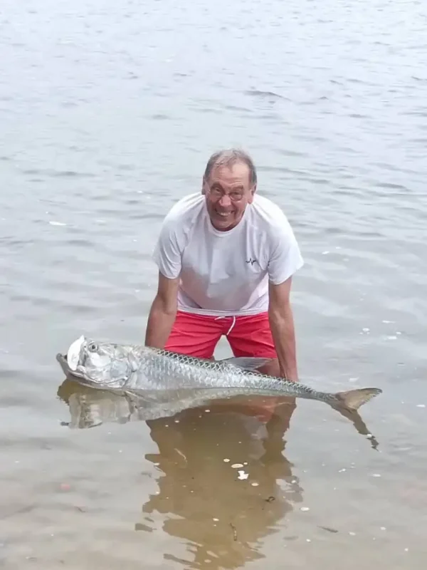 Pêcheur souriant aux côtés d’un imposant tarpon dans la lagune d’Iguéla