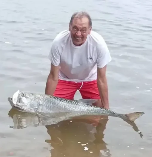Pêcheur souriant aux côtés d’un imposant tarpon dans la lagune d’Iguéla