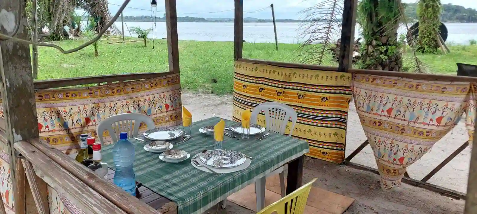 Table dressée sur la terrasse de restauration de Bangué Lodge avec vue sur la lagune d’Iguéla, dans un cadre naturel et paisible au Gabon.