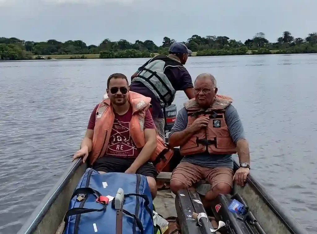 Voyageurs avec leurs bagages à bord d’une pirogue lors du transfert sur la lagune vers Bangué Lodge.