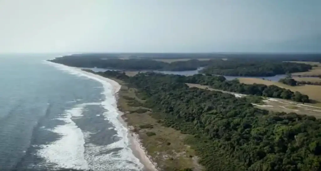 Vue aérienne de la lagune d’Iguéla au Gabon montrant la côte atlantique, les plages sauvages, la forêt tropicale et les chenaux qui relient la lagune à l’océan.