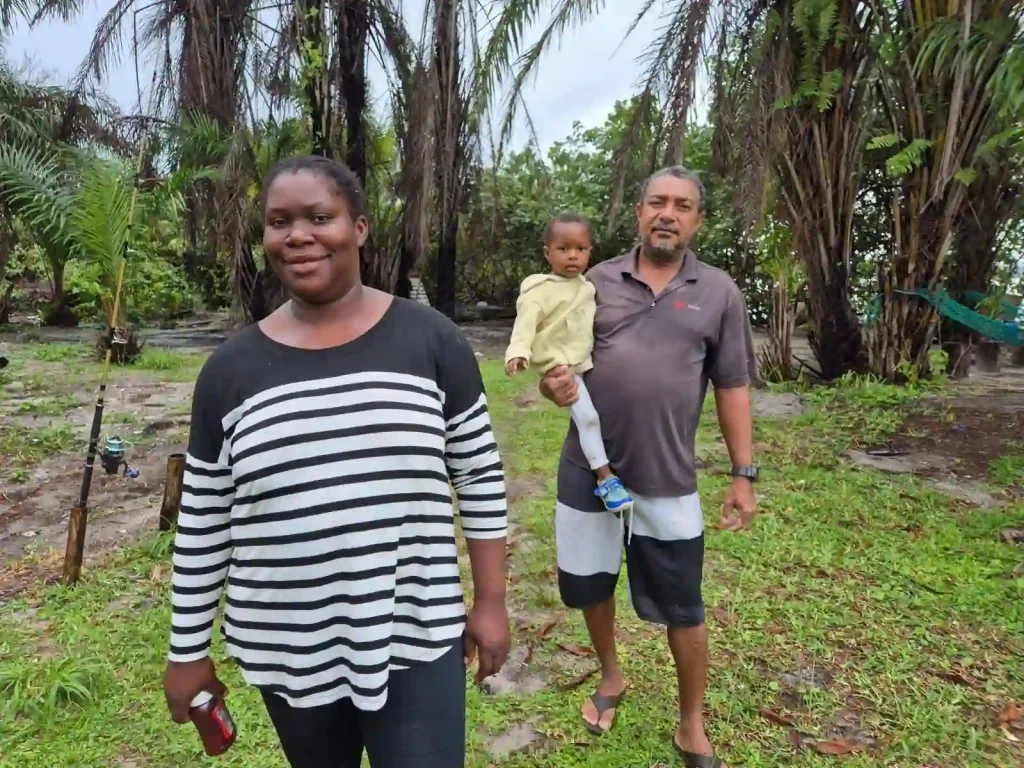 France et Christian photographiés en extérieur à Iguéla, avec un enfant, au milieu d’une végétation tropicale.