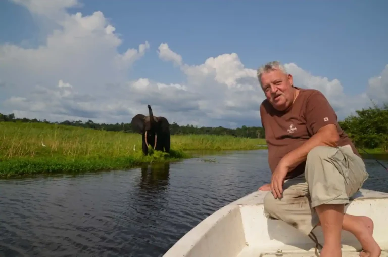 Éléphant observé depuis une embarcation sur la lagune d’Iguéla, avec un voyageur assis à l’avant du bateau.